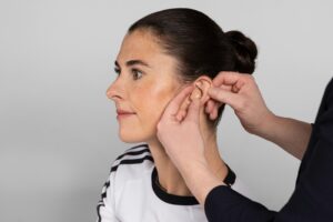 une femme met une paire de bouchons d'oreille sur son oreille